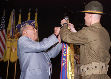 Pfc. Kevin Dixon, combat engineer,    assists Monty Montelongo, a Blackhorse veteran